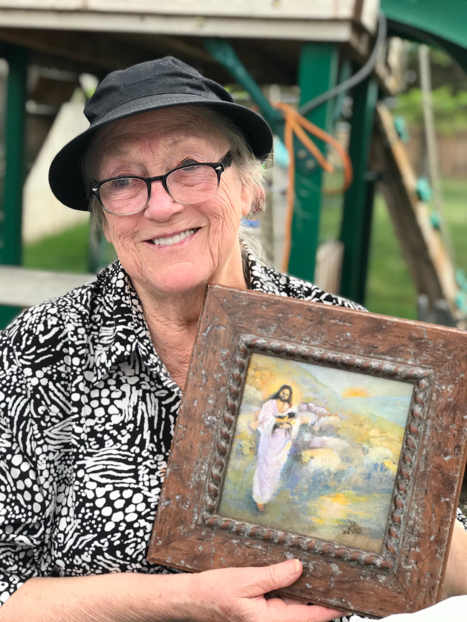 Portrait of Linda Farrar smiling and holding her painting