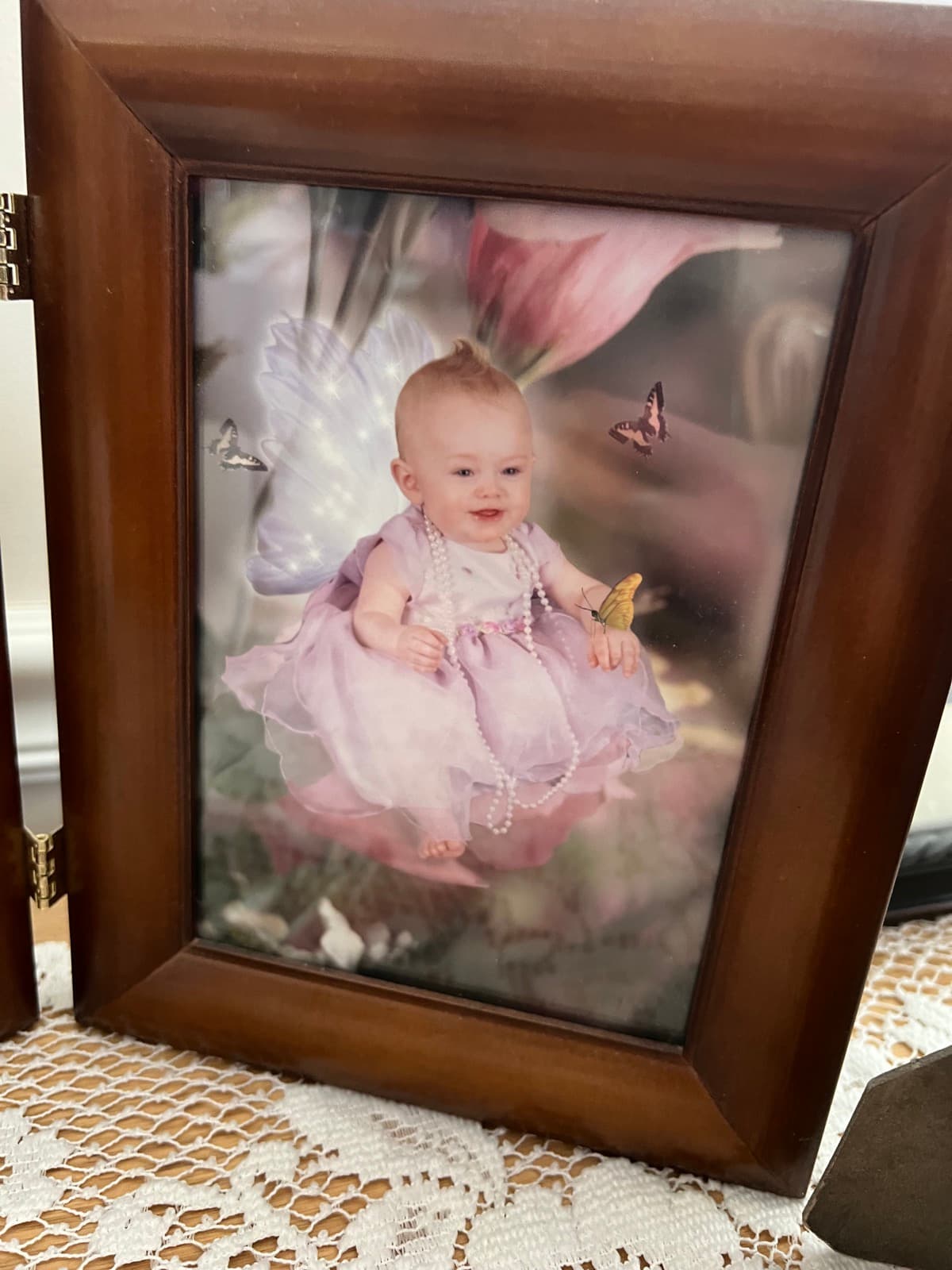 Fine art print of a baby with butterflies, surrounded by blossoms and gentle golden light