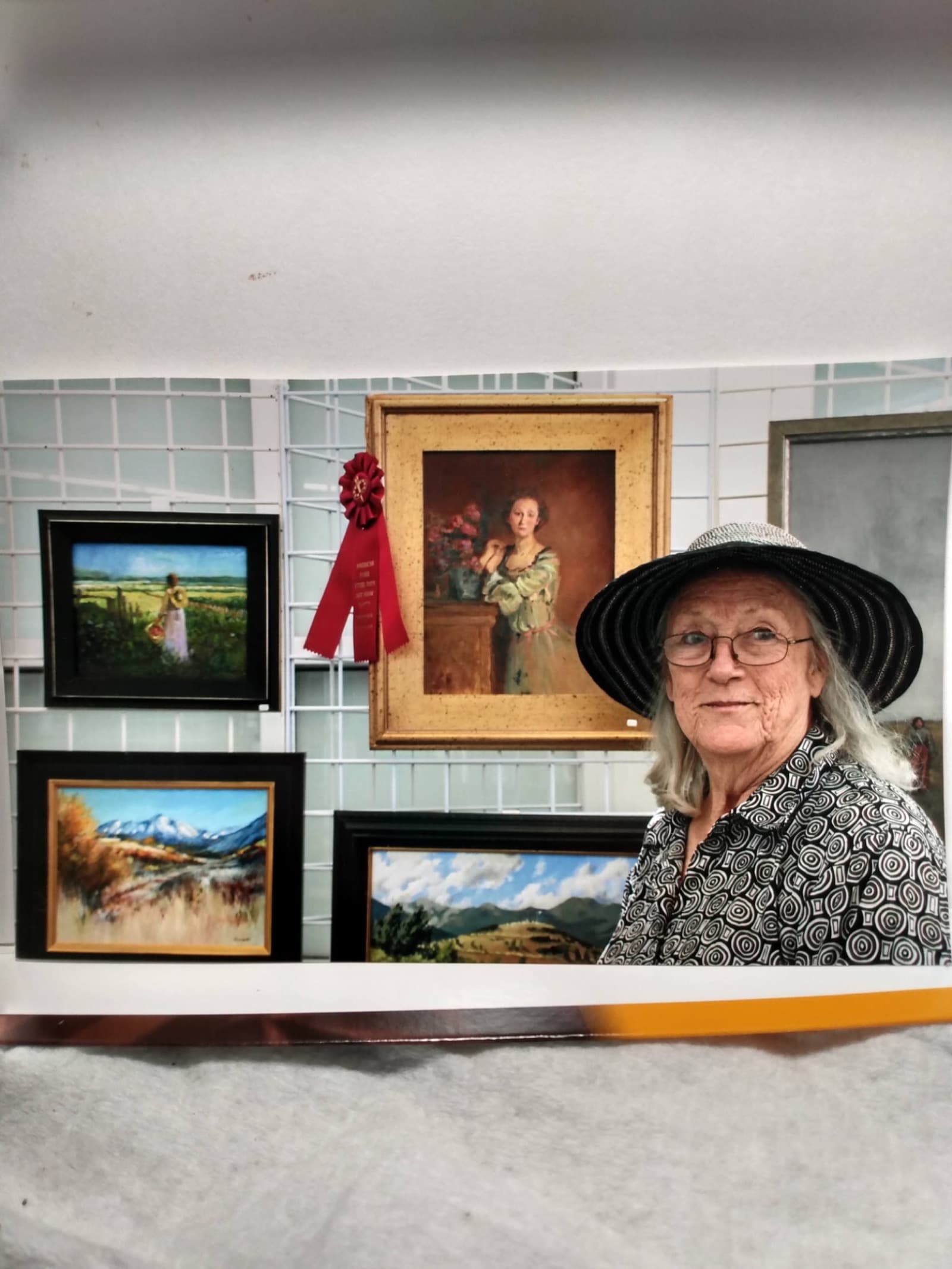 Linda Farrar's full art show display with portraits, landscapes, and award ribbons