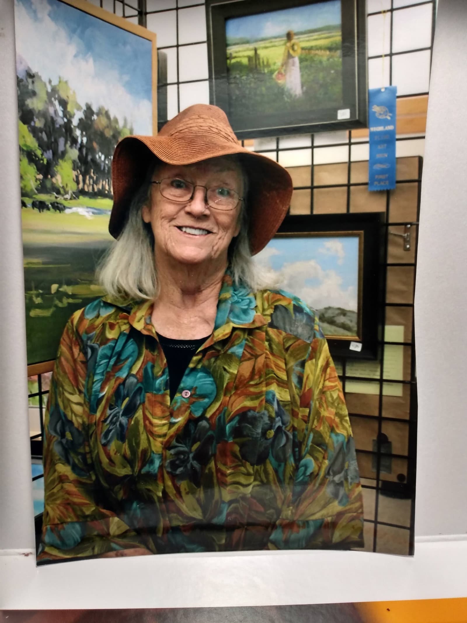 Linda Farrar at a gallery show surrounded by her paintings